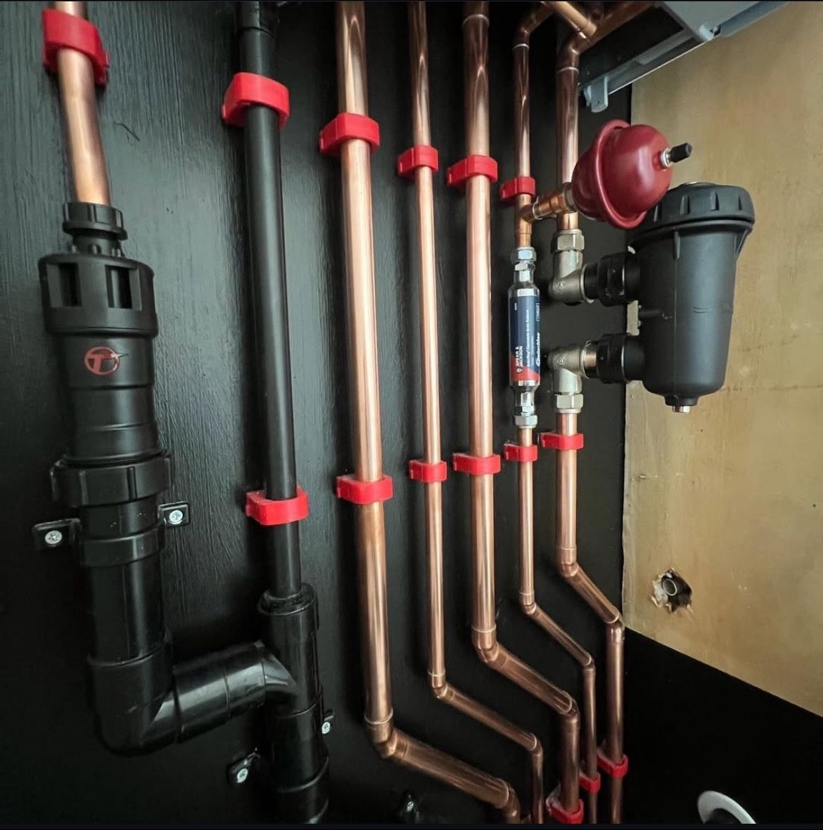 Neat copper pipework and system filter installed by a MAMOSS plumber in East London